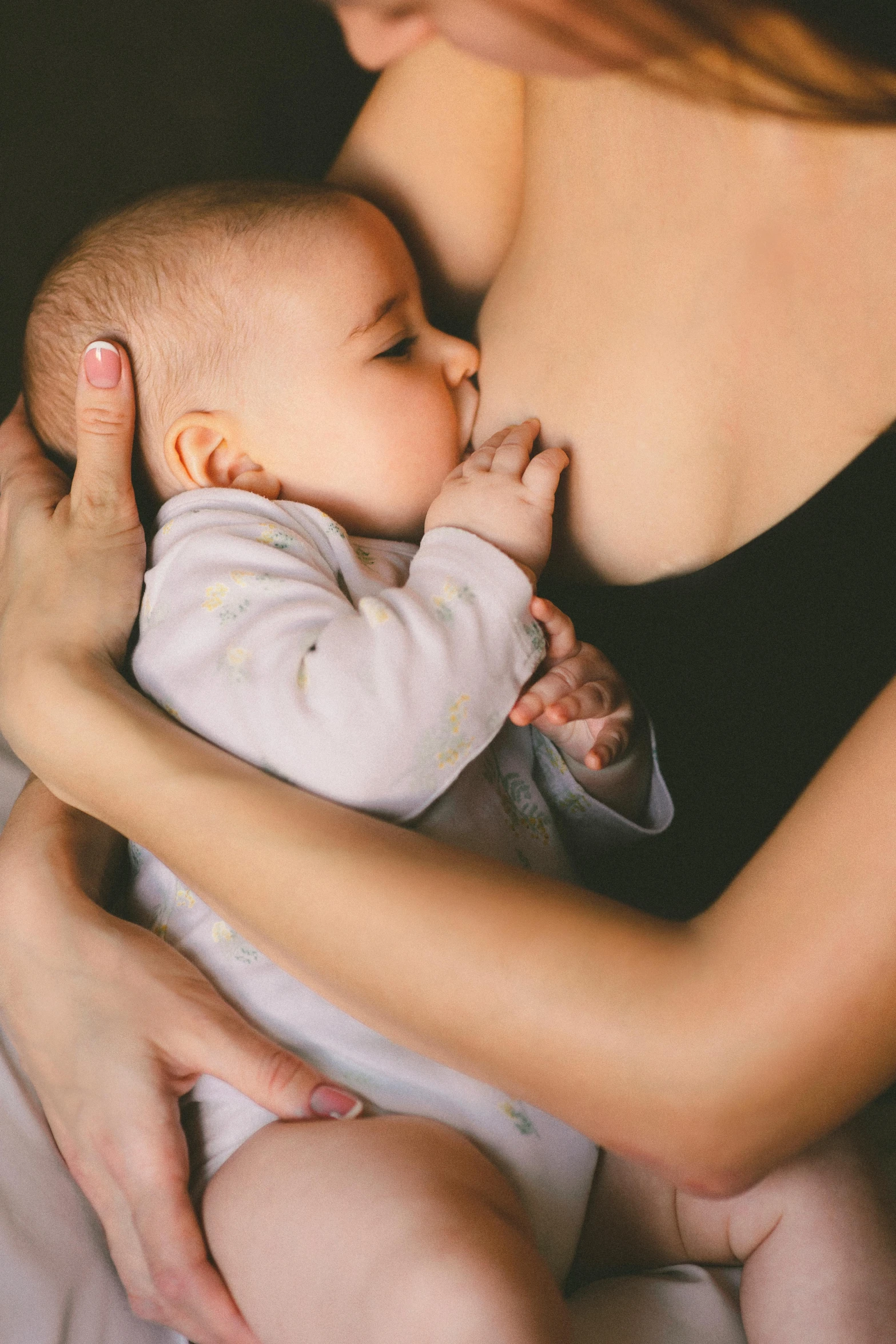 a woman holding a baby in her arms, pexels, square, bra, holding a milkor mgl, making out