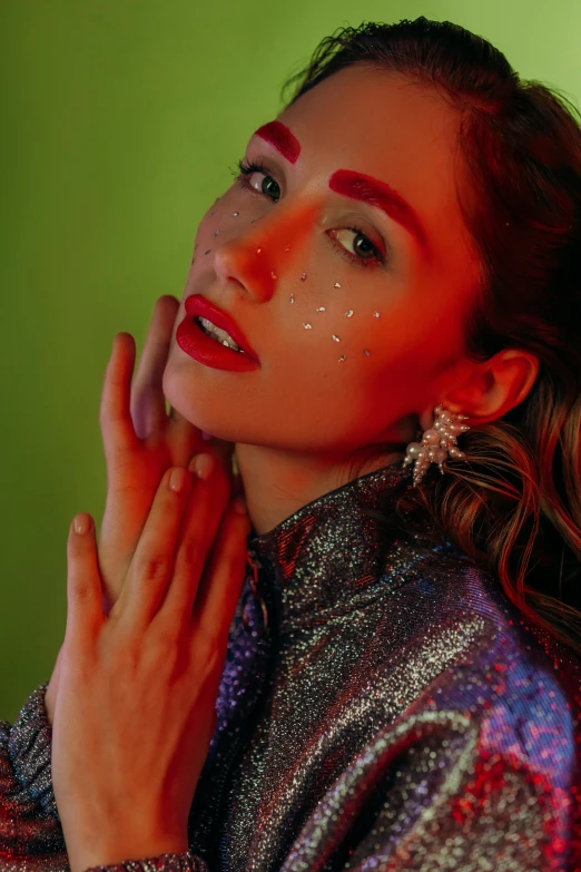 a woman standing in front of a green wall, an album cover, by Julia Pishtar, trending on pexels, holography, glitter makeup, red and white neon, close - up studio photo, deity)