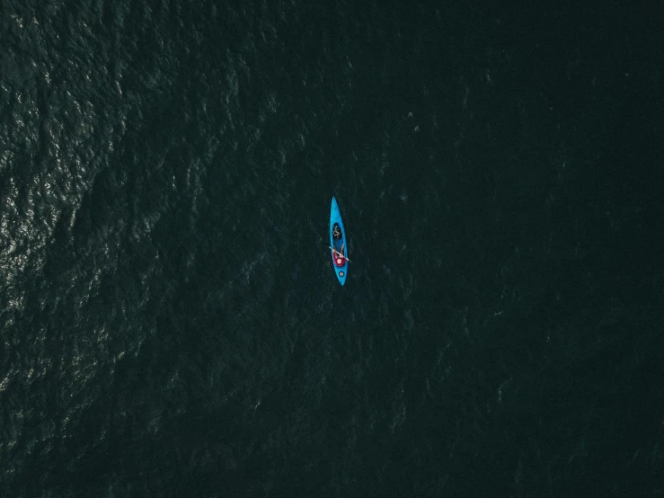 a small boat in the middle of a large body of water, by Adam Marczyński, pexels contest winner, deep blue ocean color, sport, paddle of water, gif