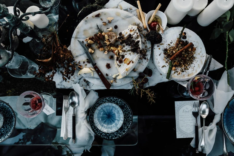 a table topped with plates of food and silverware, by Caroline Mytinger, pexels contest winner, renaissance, moody aesthetic, partially bloody crystallized, seasonal, pose 4 of 1 6