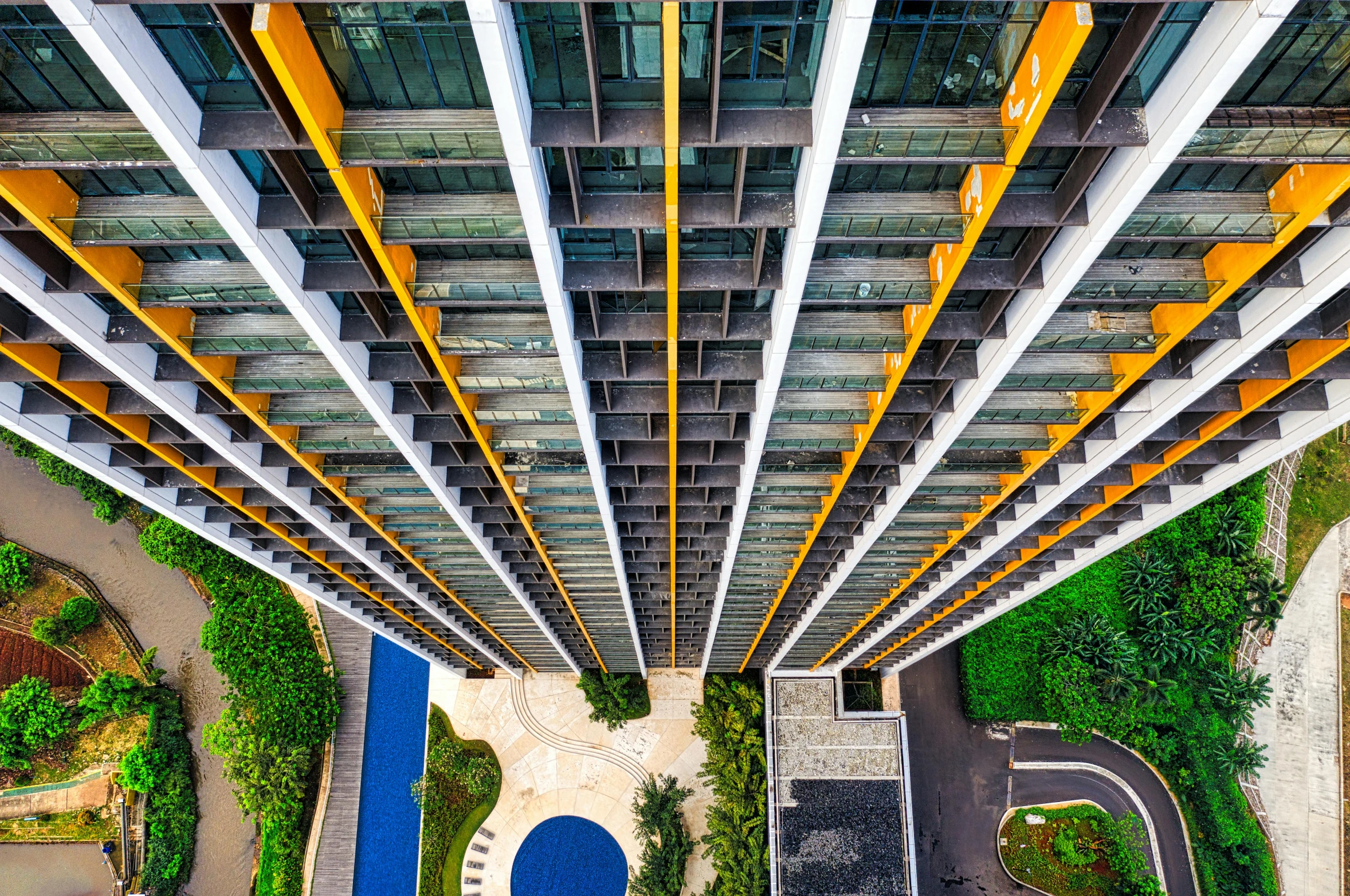 a very tall building with a pool in the middle of it, inspired by Cheng Jiasui, unsplash contest winner, yellow windows and details, high angle uhd 8 k, hyperdetailed colourful, elegant walkways between towers