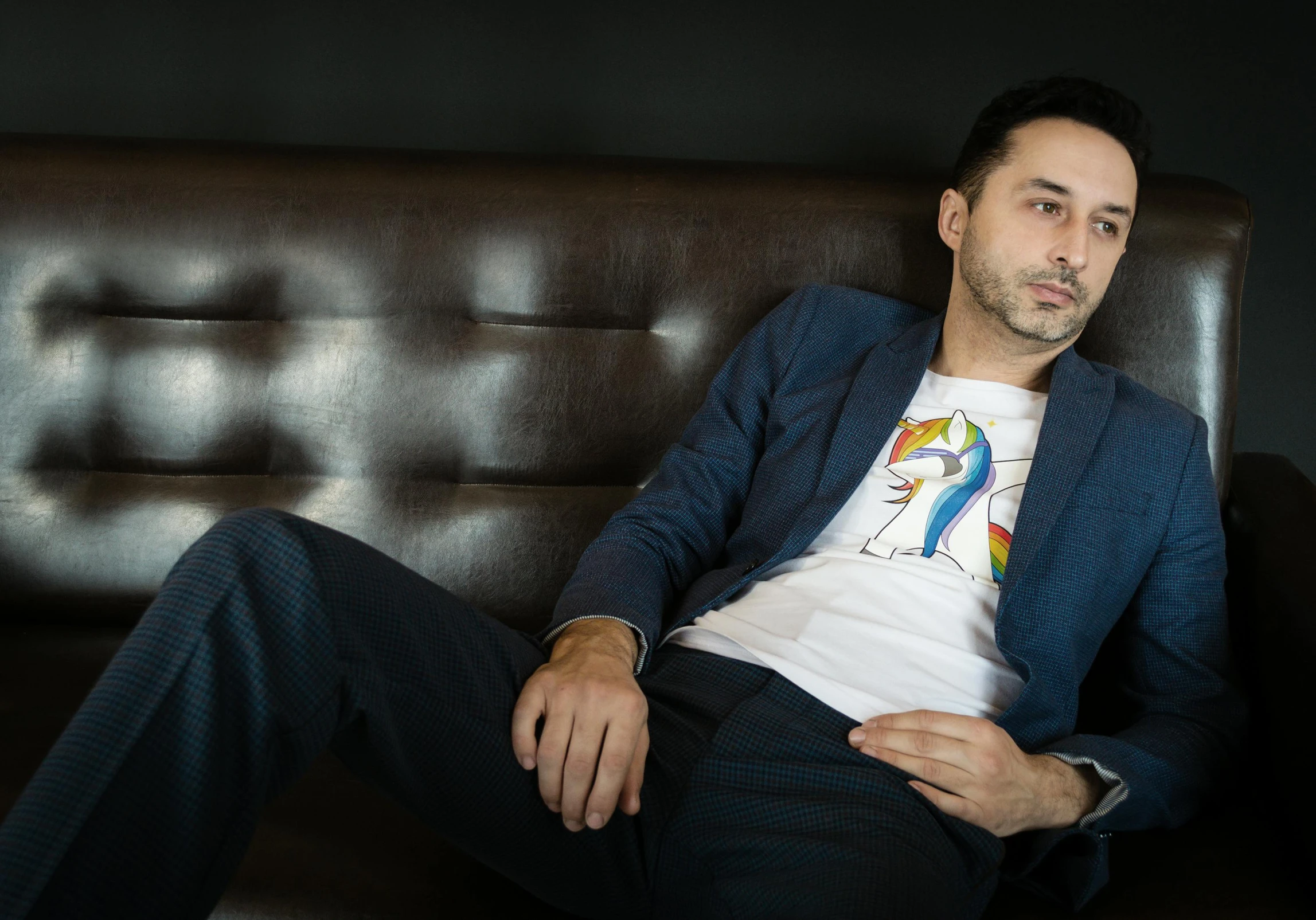 a man in a suit sitting on a couch, inspired by david rubín, pexels contest winner, hurufiyya, wearing a shirt and a jean, adar darnov, lgbtq, promotional image