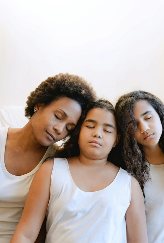 a group of women sitting on top of a bed, caring fatherly wide forehead, hard breathing, diverse ages, three heads