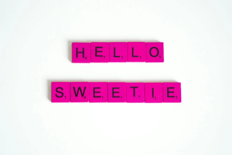 pink scrabbles spelling hello and sweetie on a white surface, 🎀 🗡 🍓 🧚, avatar for website, product shoot, seductive