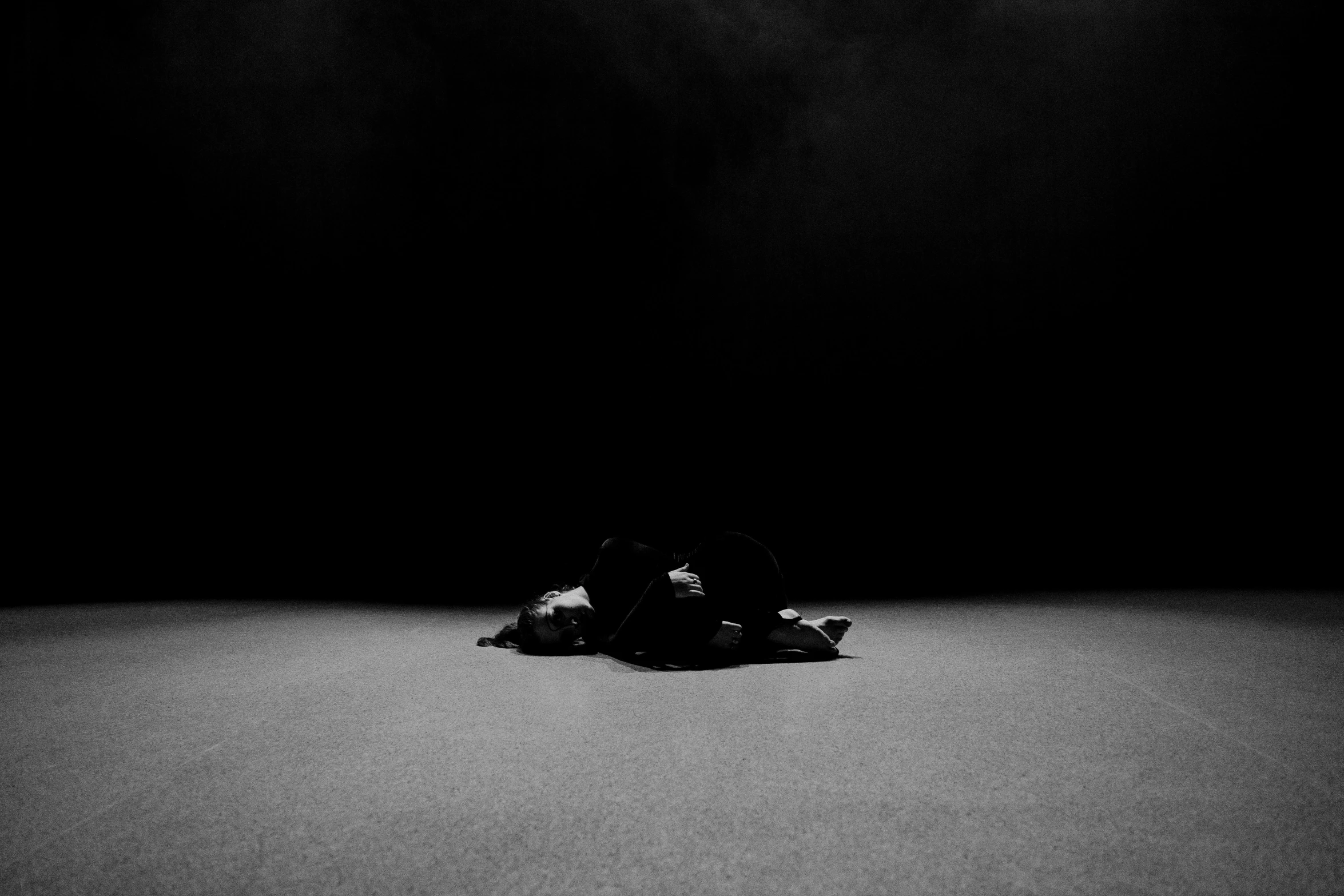 a person laying on the ground in the dark, an album cover, by Sergio Burzi, black sand, dark monochrome, artwork empty daylight, ritual