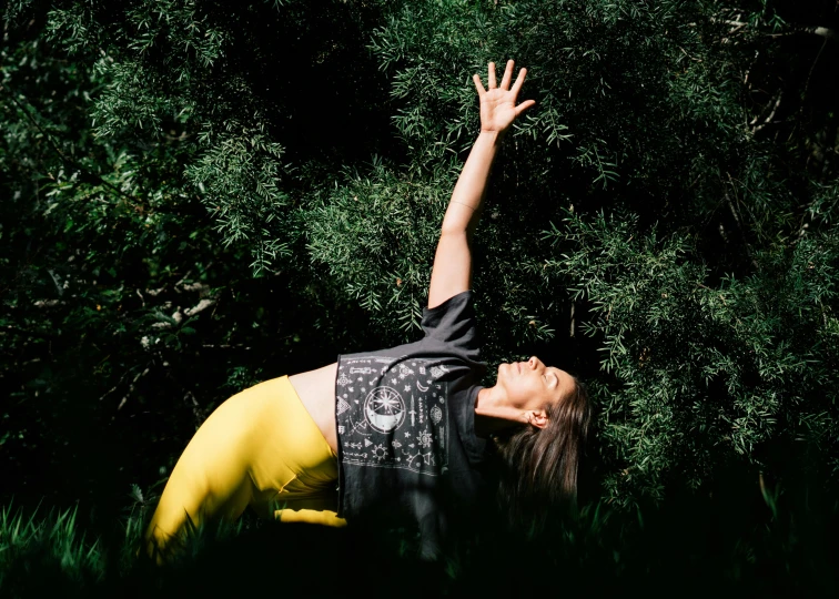 a woman reaching up to catch a frisbee, a portrait, unsplash, happening, yoga pose, covered in plants, she is laying on her back, sydney park