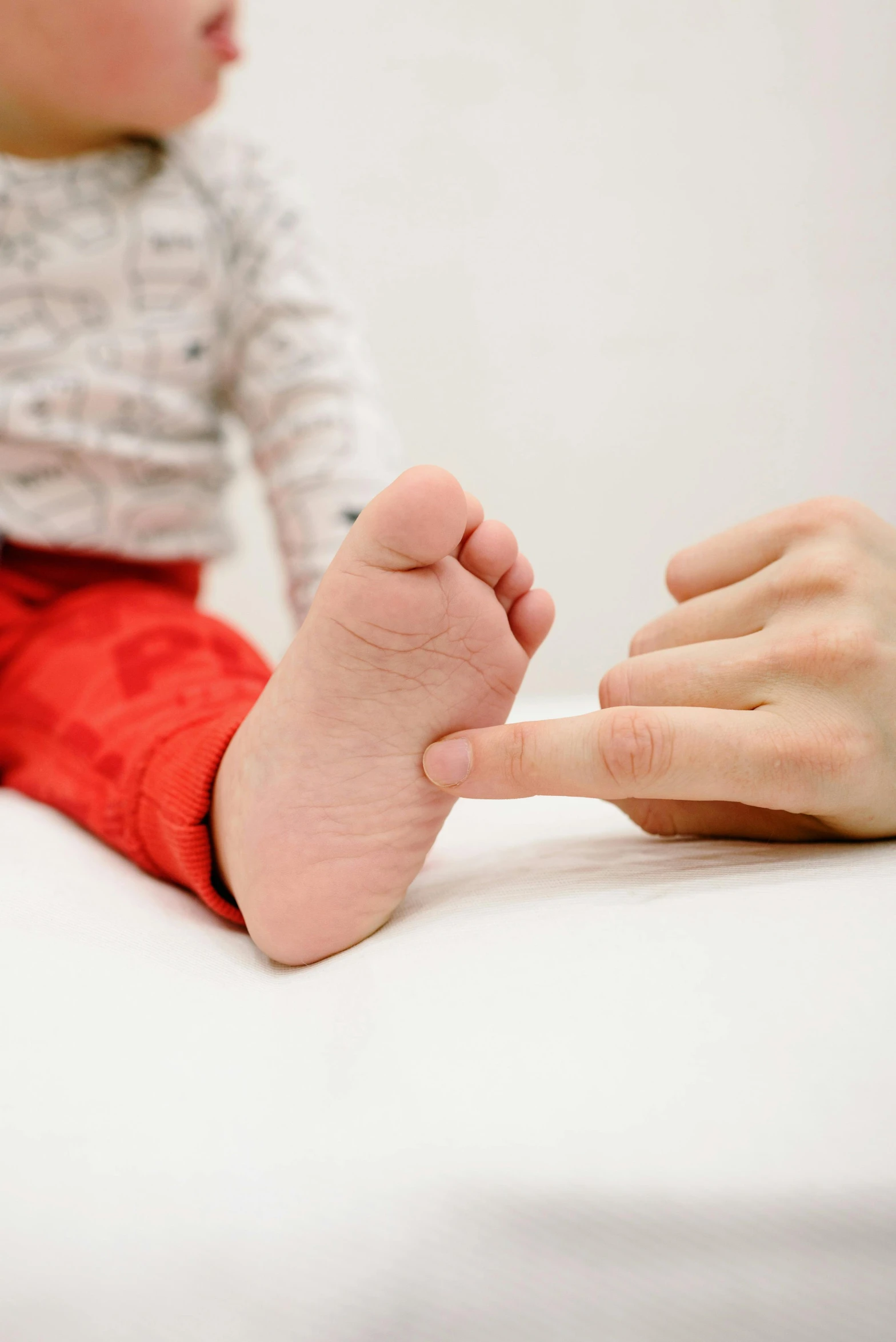 a baby sitting on top of a bed next to a woman, by Victorine Foot, pexels, anatomical, kid named finger, diagnostics, square