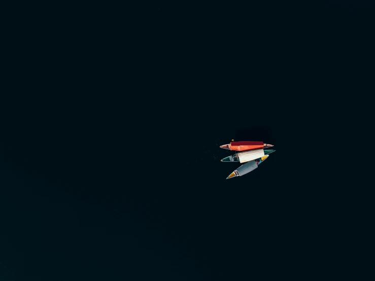 a small boat floating on top of a body of water, by Matthias Weischer, unsplash, minimalism, flying spaceships, colorful and dark, small elongated planes, ceiling hides in the dark