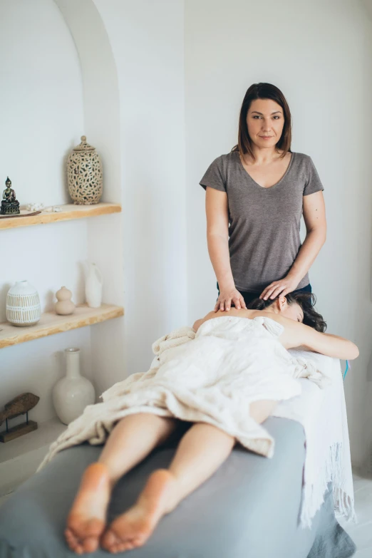 a woman getting a massage at a spa, a portrait, by Arabella Rankin, on a white table, grey, lynn skordal, natural and organic and flowing