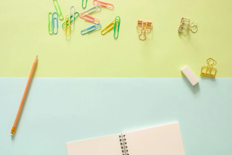 a notepad sitting on top of a desk next to a pencil, an album cover, background image, colourful pastel, made of paperclips, thumbnail