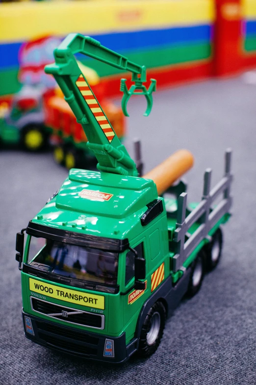 a toy truck with a crane on top of it, by Paul Bird, pexels contest winner, deep green, closeup of arms, activity play centre, product display photograph