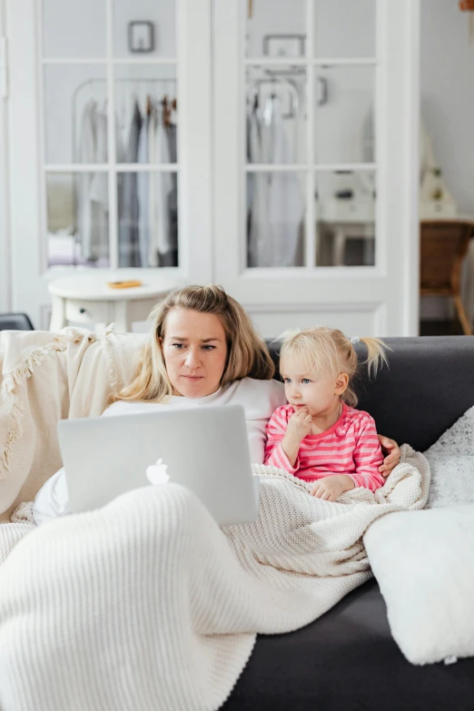 a woman and child sitting on a couch with a laptop, pexels, square, watching tv, high quality photo, caucasian