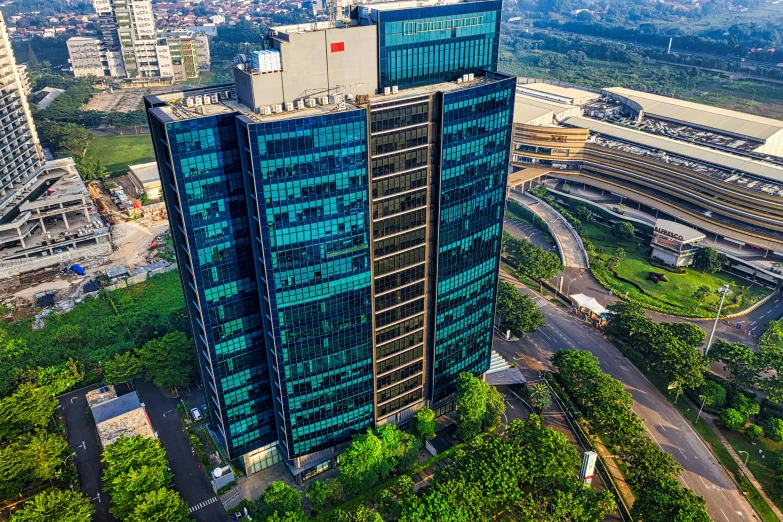 a tall building sitting on top of a lush green hillside, jakarta, ultrastation hq, thumbnail, aerial