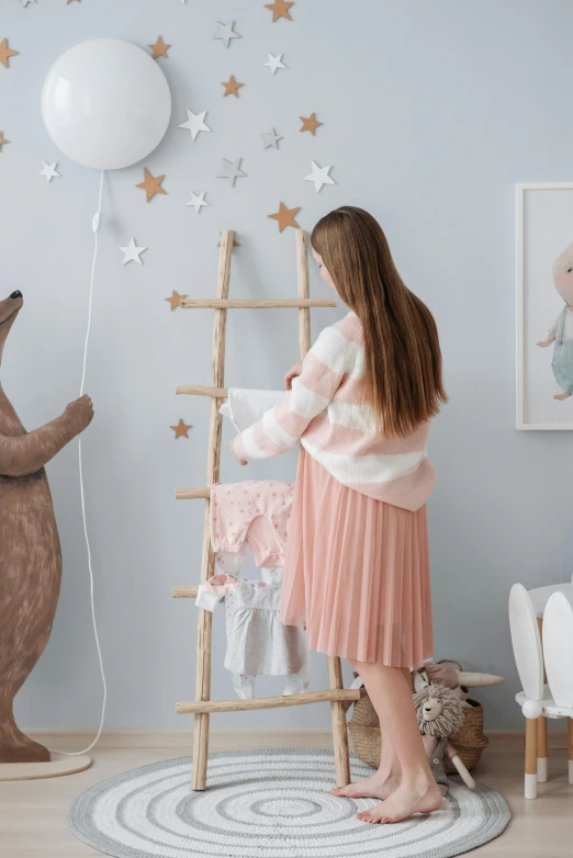 a little girl standing next to a teddy bear, poster art, by Julia Pishtar, pexels contest winner, standing on a ladder, decoration around the room, touching her clothes, trending on artstion