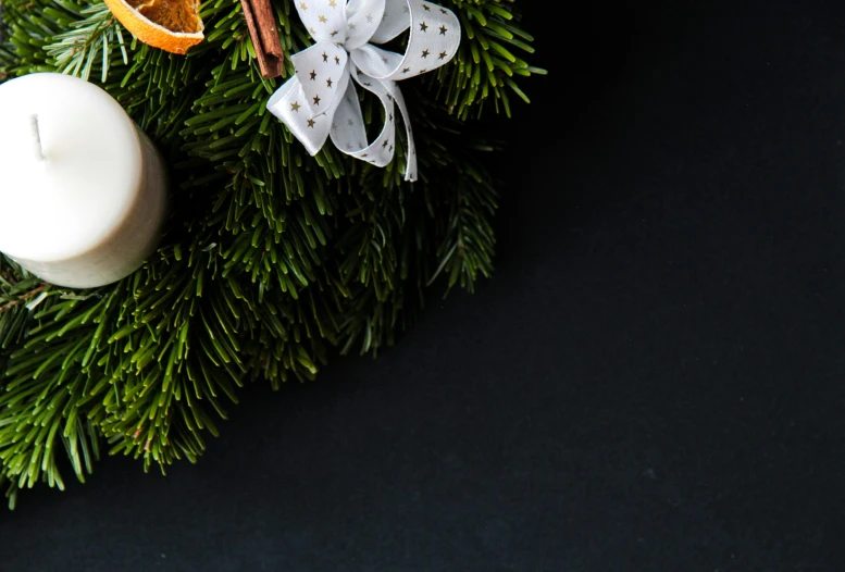 a close up of a christmas wreath with a candle, a still life, pexels contest winner, hurufiyya, white and orange, background image, ribbon, programming