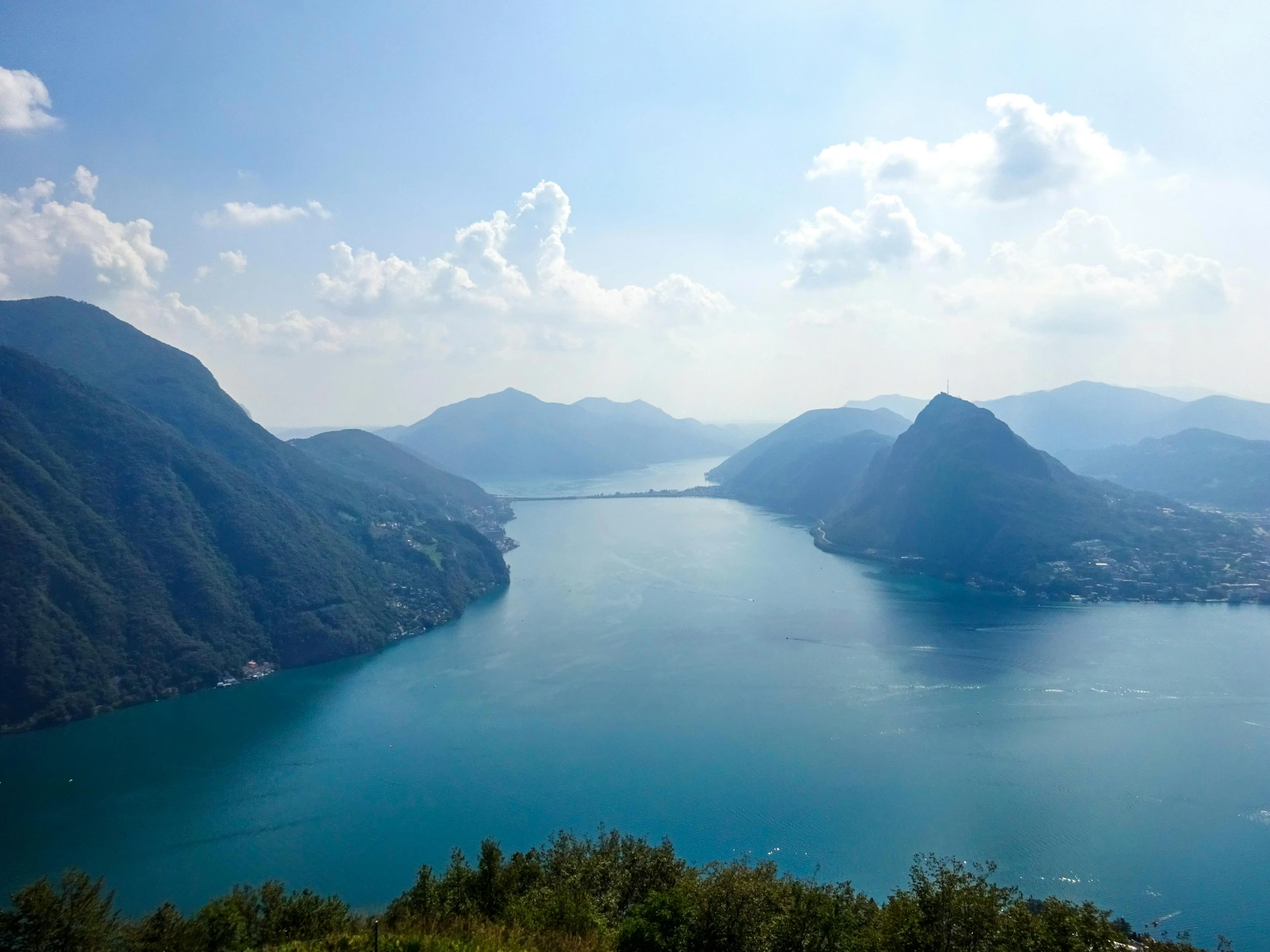 a large body of water surrounded by mountains, inspired by Tadao Ando, pexels contest winner, vouge italy, vallejo, light blue water, landscape view