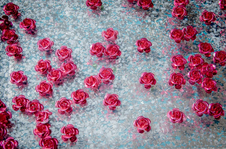 a bunch of red roses sitting on top of a table, by Julia Pishtar, process art, embedded with gemstones, teal silver red, pink water in a large bath, glossy surface