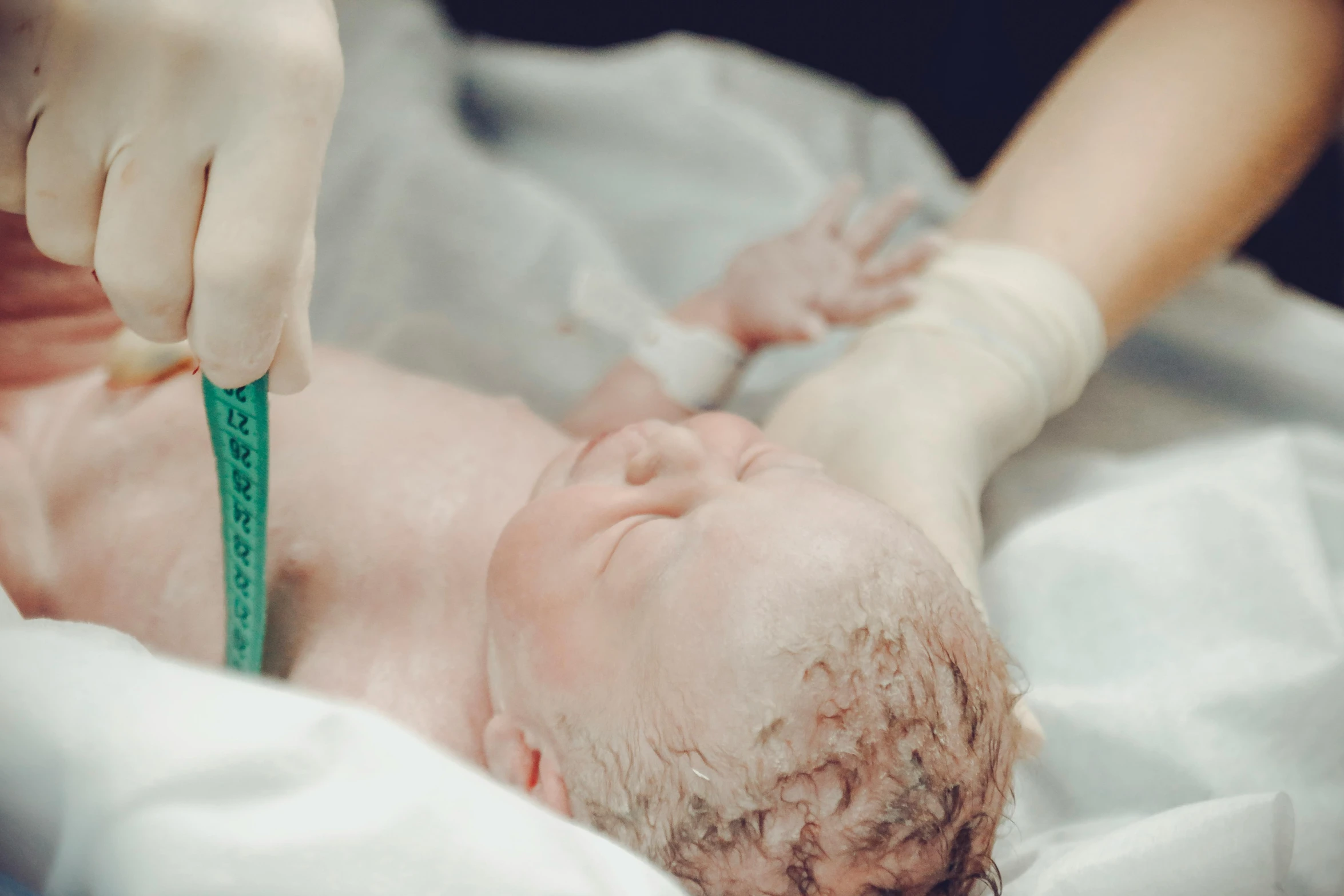 a close up of a person putting a tape on a baby, anaesthetic, wētā fx, thumbnail, no cropping