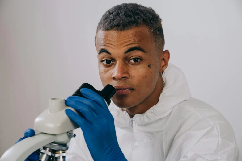 a man in a lab coat looking through a microscope, inspired by Frank Mason, pexels contest winner, yung lean, portrait n - 9, riyahd cassiem, wearing human air force jumpsuit