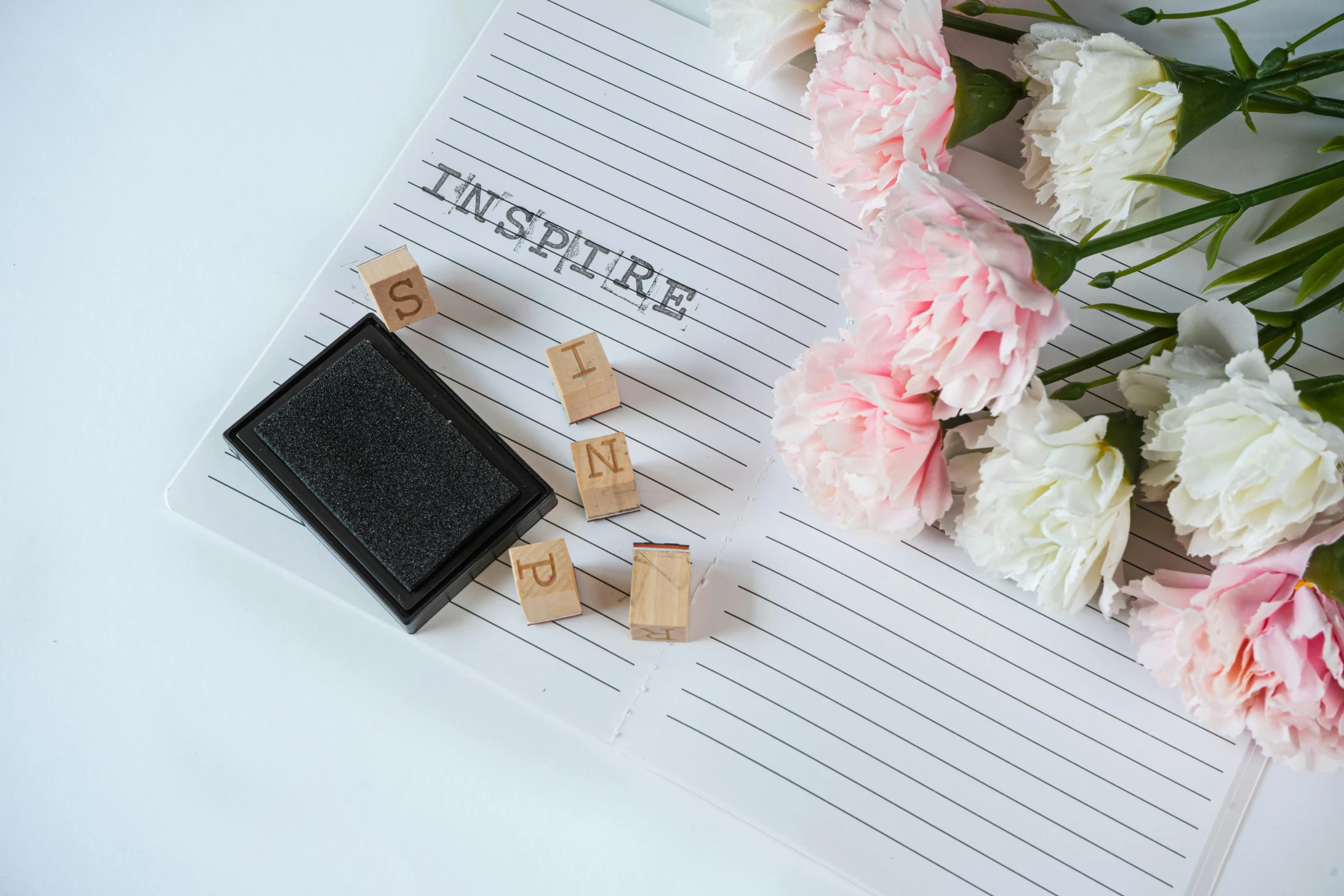 a notepad sitting on top of a pile of flowers, inspired by Sophia Beale, unsplash, private press, cubes on table, stamp, miniature product photo, teacher