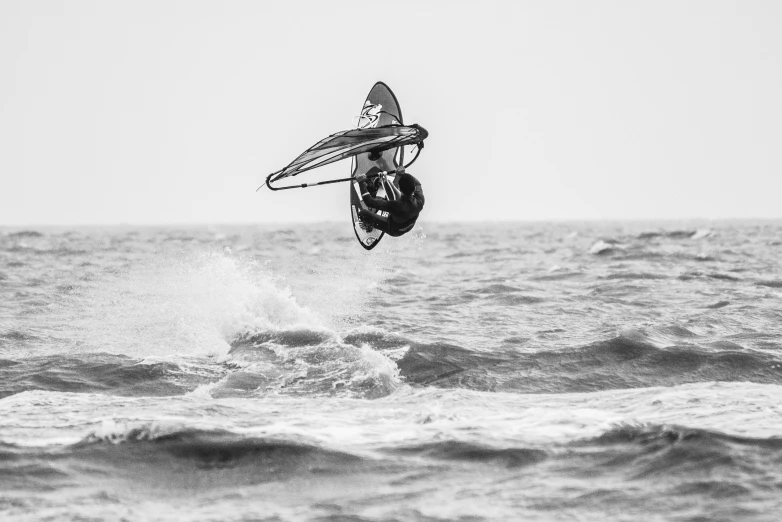 a man flying through the air while riding a kiteboard, a black and white photo, by Matthias Weischer, pexels contest winner, surfing a barrel wave, sail, concert photo, on the coast