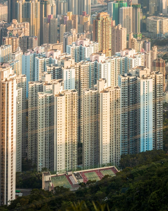 a group of tall buildings sitting on top of a lush green hillside, by Patrick Ching, pexels contest winner, modernism, apartment complex made of tubes, dramatic warm morning light, asian hyperdetailed, 2 0 7 7