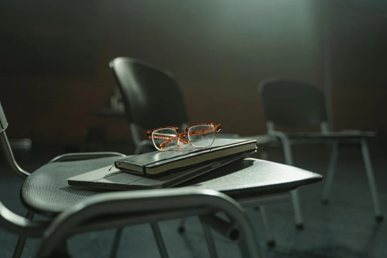 a stack of books sitting on top of a chair, by Carey Morris, pexels, hyperrealism, photo of a classroom, square rimmed glasses, cinematic image, audience