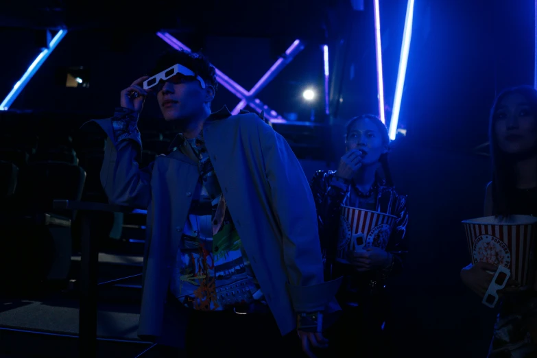 a group of people that are standing in the dark, unsplash, holography, japanese streetwear, medium shot of two characters, high blue lights, behind the scenes photo