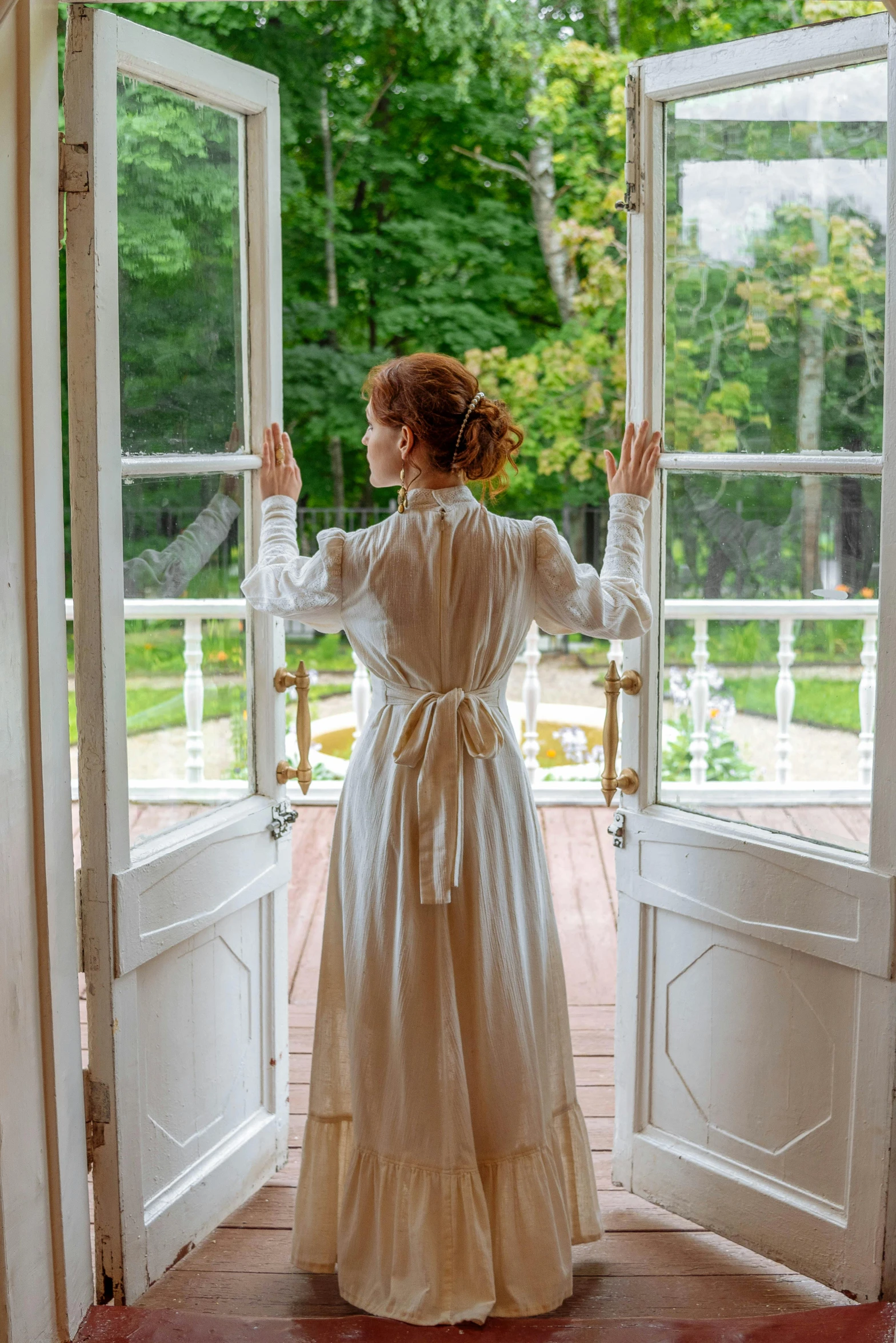 a woman standing in front of an open door, inspired by Albert Edelfelt, pexels contest winner, renaissance, dressed in white, at the terrace, jessica chastain, cottagecore