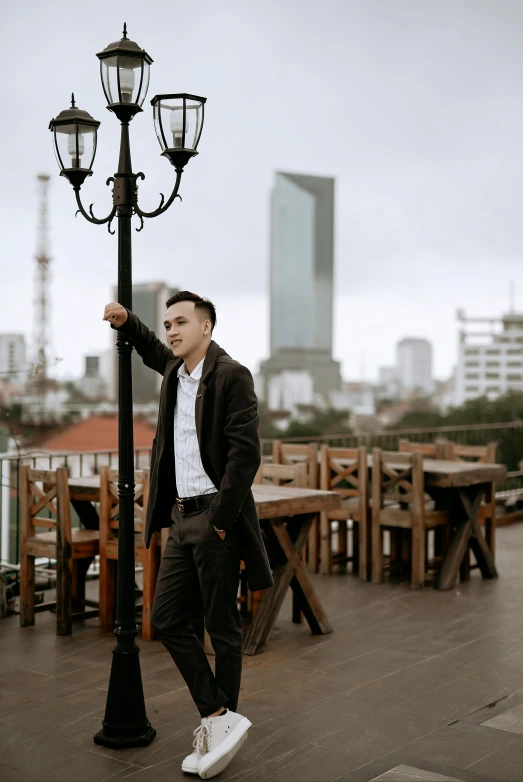 a man in a suit leaning against a lamp post, an album cover, pexels contest winner, dang my linh, city rooftop, at the terrace, casual pose