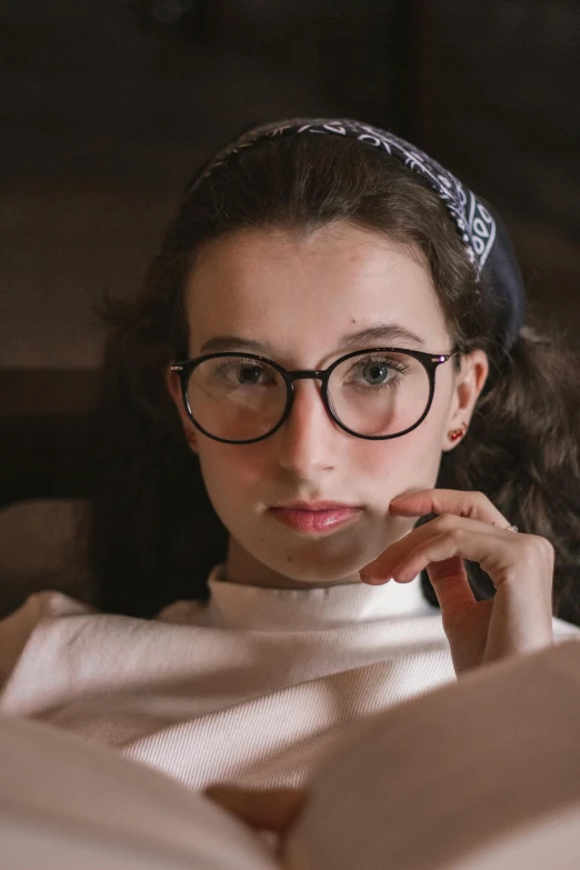 a woman reading a book while wearing glasses, inspired by Raphael Soyer, renaissance, close-up portrait film still, beautiful jewish woman, portrait featured on unsplash, high quality picture