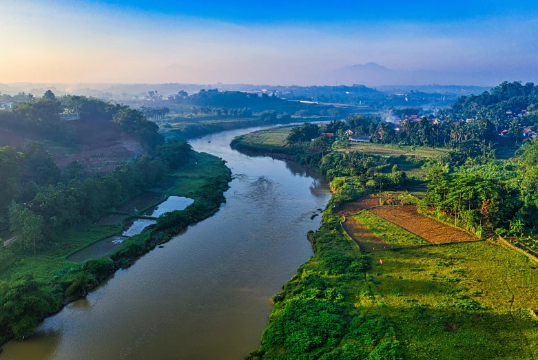 a river running through a lush green countryside, by Daniel Lieske, pexels contest winner, sumatraism, panoramic view, guangjian huang, cinematic morning light, blue river in the middle