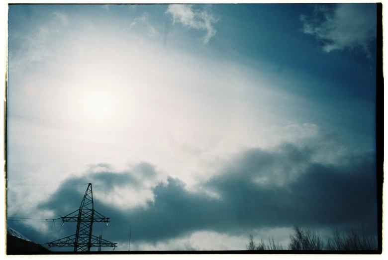 a cloudy sky with power lines in the foreground, by Karl Buesgen, medium format. soft light, the sun is shining. photographic