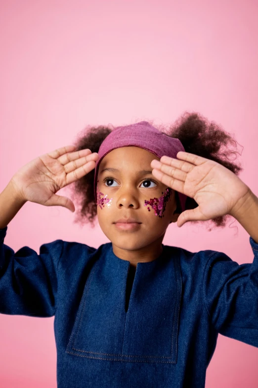 a little girl covering her eyes with her hands, an album cover, trending on pexels, graffiti, pink headband, adinkra symbols, insect trainer girl, face painting