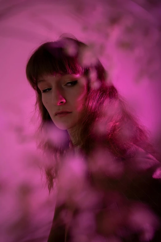 a woman looking at her reflection in a mirror, inspired by Elsa Bleda, bright pink purple lights, with flowers, pink grass, looking towards camera