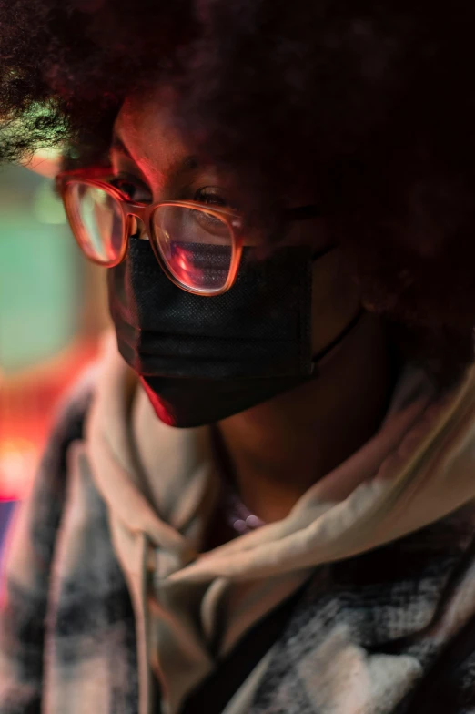 a close up of a person wearing a face mask, afrofuturism, wearing black rimmed glasses, warm glow from the lights, student, concerned