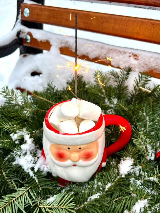 a close up of a cup of hot chocolate with marshmallows, by Elaine Hamilton, sitting on santa, outdoors lighting, official product photo, firefly lights
