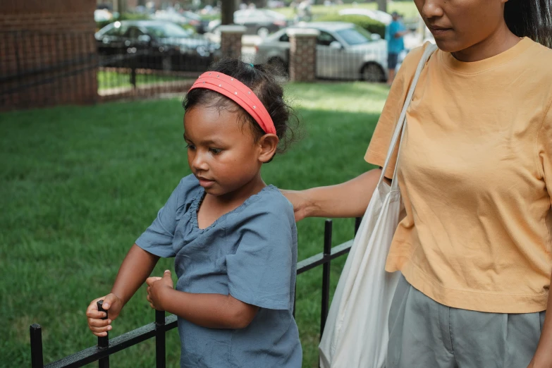 a woman standing next to a little girl, by Andrew Stevovich, pexels contest winner, african american, people outside walk, over the shoulder, 15081959 21121991 01012000 4k