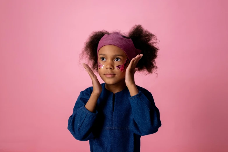 a little girl holding her hands up to her face, a child's drawing, trending on pexels, graffiti, photoshoot for skincare brand, pink headband, ( ( dark skin ) ), fancy dress