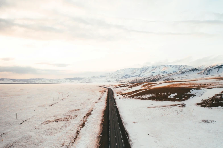 a long road in the middle of a snowy field, unsplash contest winner, overlooking a valley, flat lay, from of thrones, vsco