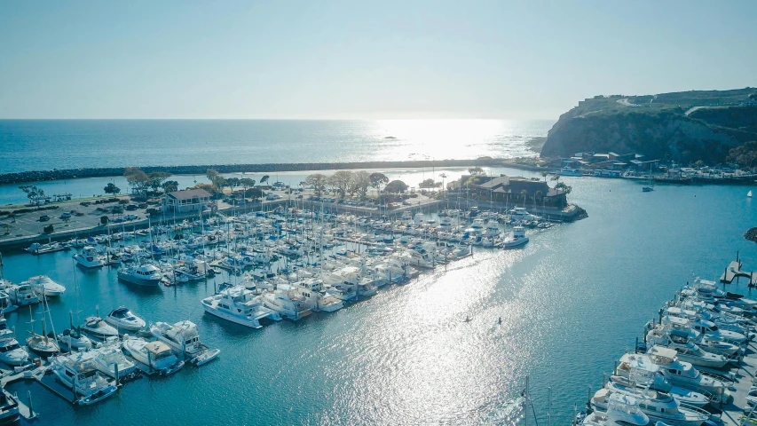 a marina filled with lots of white boats, pexels contest winner, malibu canyon, aerial, overlooking the ocean, sun lit