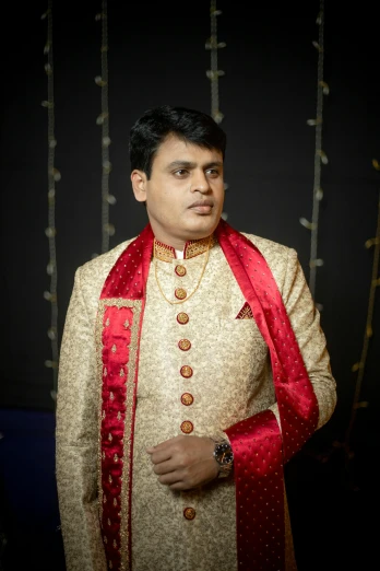 a man in a white and red sherwani, principal photography, non-binary, wearing robes and neckties, high quality upload