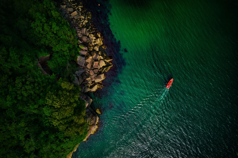 a small boat in the middle of a body of water, pexels contest winner, green bright red, air shot, manly, ben lo