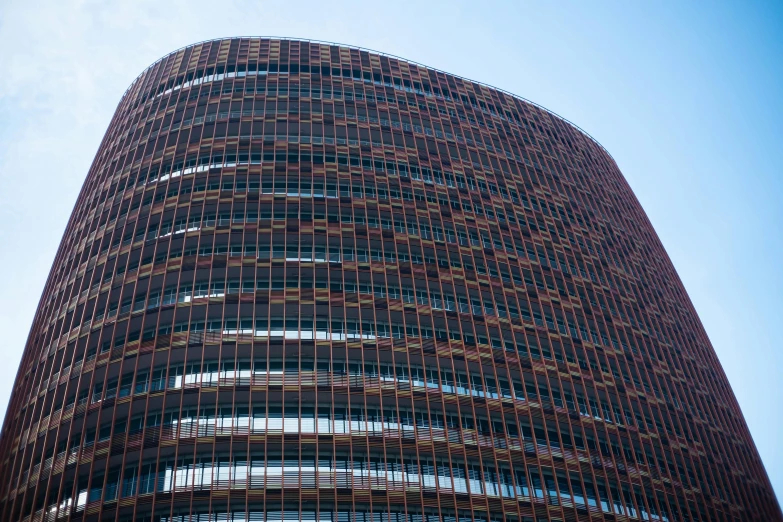 a very tall building with a lot of windows, inspired by Tadao Ando, pexels contest winner, brown red blue, rounded roof, brown, terracotta