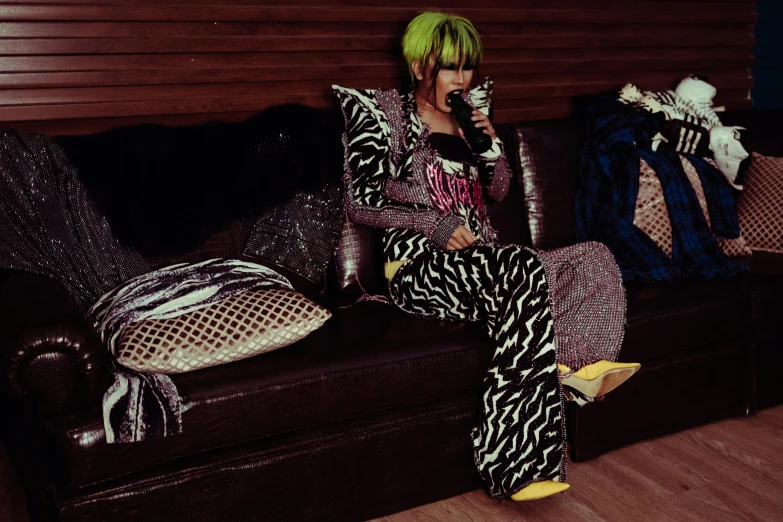 a woman with green hair sitting on a couch, inspired by Elsa Bleda, instagram, graffiti, bright trouser suit for a rave, kousuke oono, press shot, bedazzled