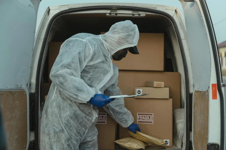 a man in a protective suit loading boxes into a van, pexels contest winner, scientific, brown, 6, multi-part