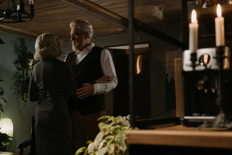 a man and a woman standing next to each other, happening, cosy atmosphere, dark grey haired man, owen gent, medium-shot