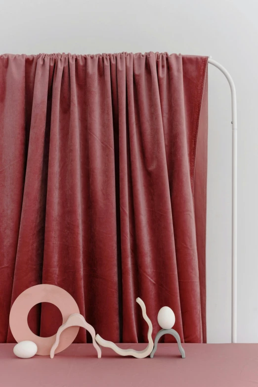 a lamp sitting on top of a table next to a curtain, by Luma Rouge, trending on pexels, red clothes, pink arches, corduroy, close-up product photo