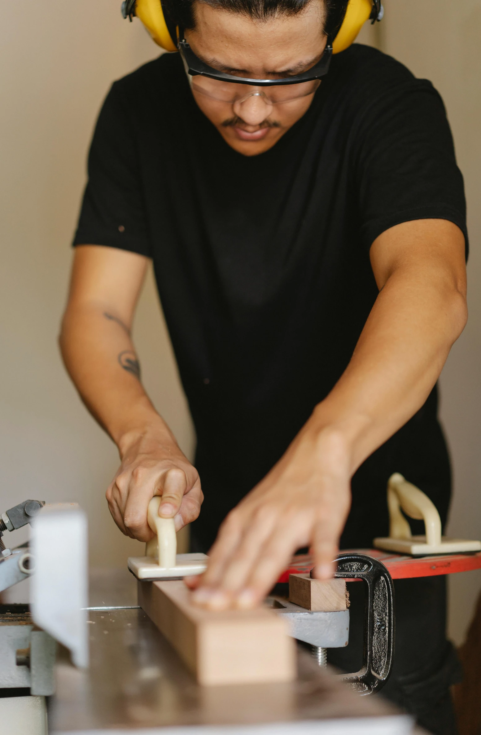 a man with headphones working on a piece of wood, a silk screen, by Robbie Trevino, holding magical kitchen knives, resin and clay art, aussie baristas, profile image