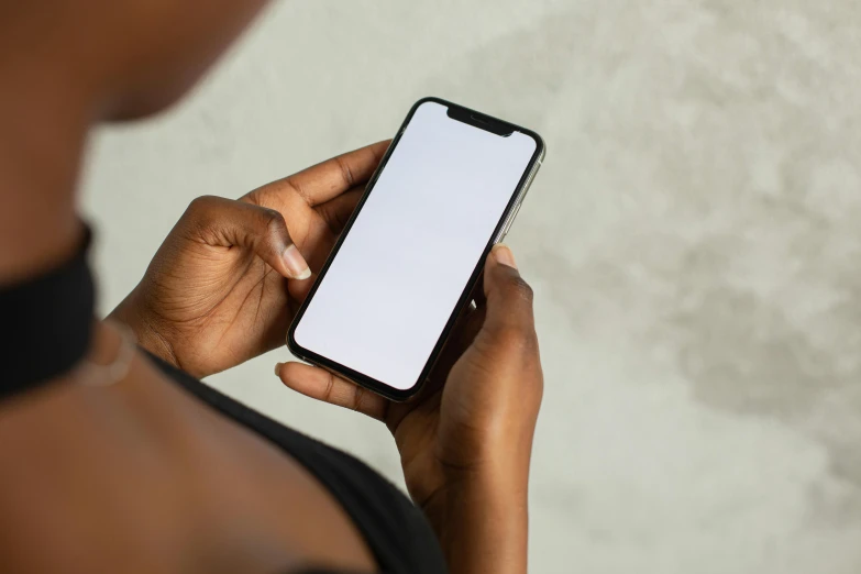 a close up of a person holding a cell phone, trending on pexels, portrait of ororo munroe, plain background, 16k resolution:0.8, inviting posture